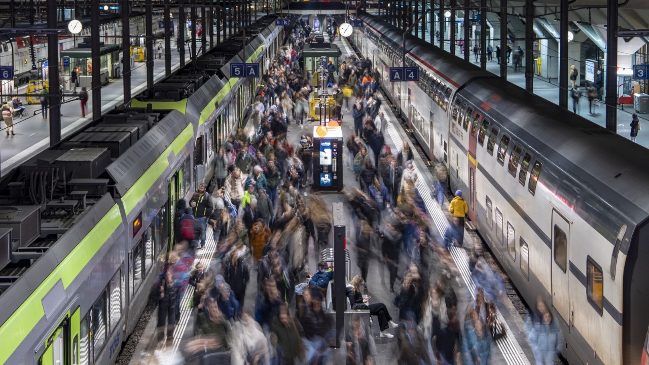 Das Bild zeigt die Bahnhofshalle Luzern zur Hauptverkehrszeit mit hohem Passagieraufkommen auf dem Perron der Gleise 4 und 5.