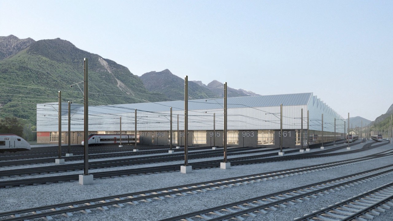 Visualizzazione della facciata esterna rivolta a sud-est, con parte dell’impianto di ricovero e i binari di transito. Sulla parte inclinata del tetto si vede l’impianto fotovoltaico per l’autoproduzione di energia elettrica.